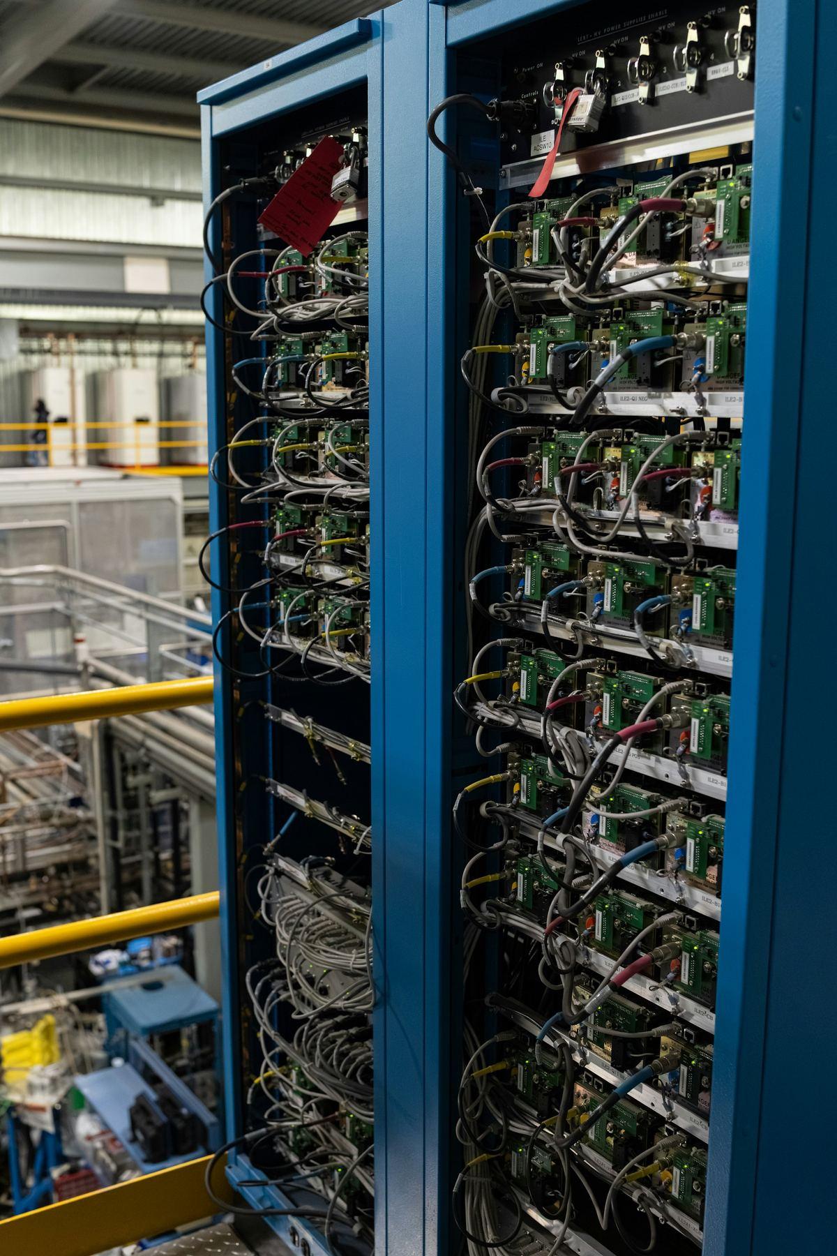 Blue server racks with connected electronic components and cables